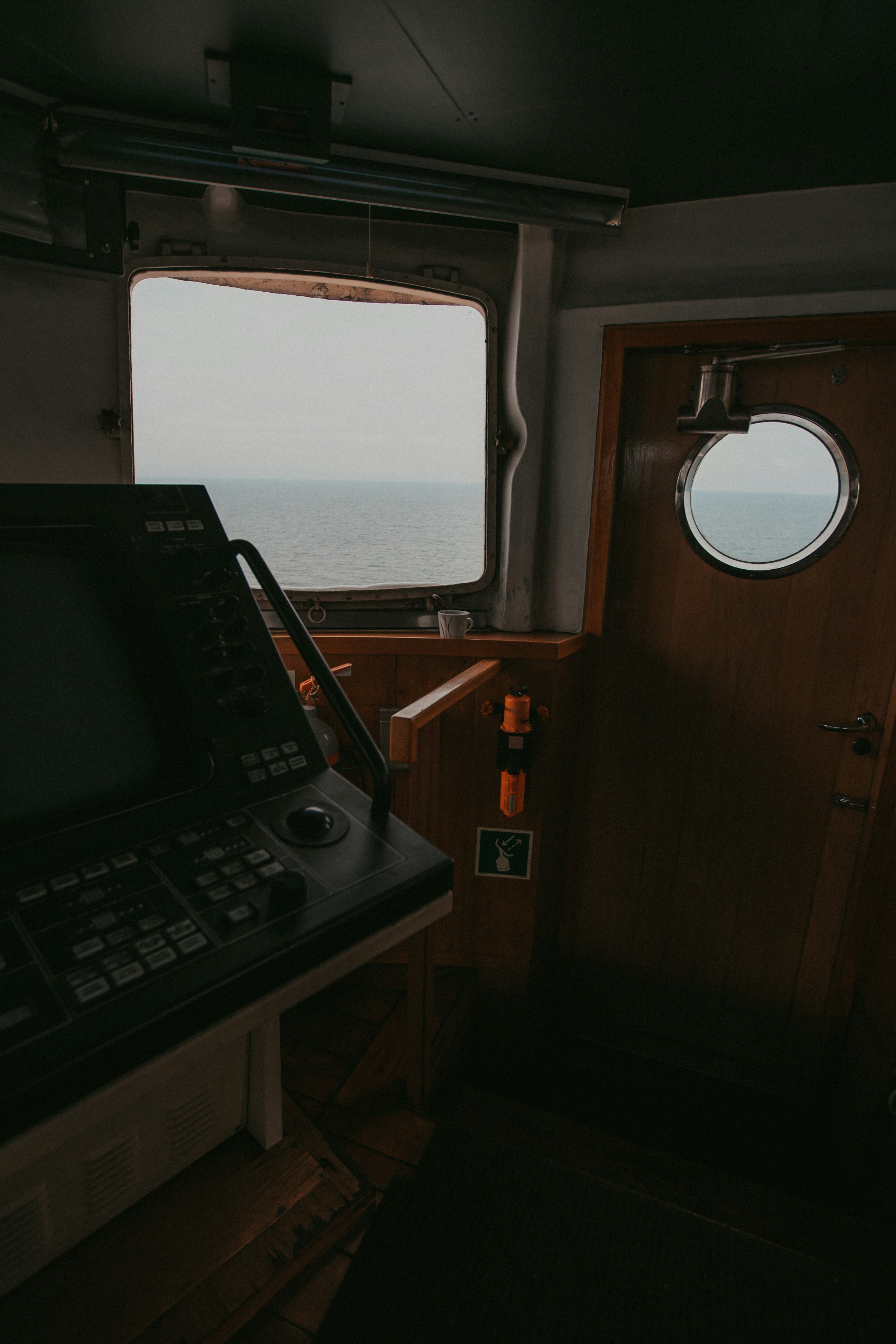 Navigation display and console inside a darkened vessel bridge at sea