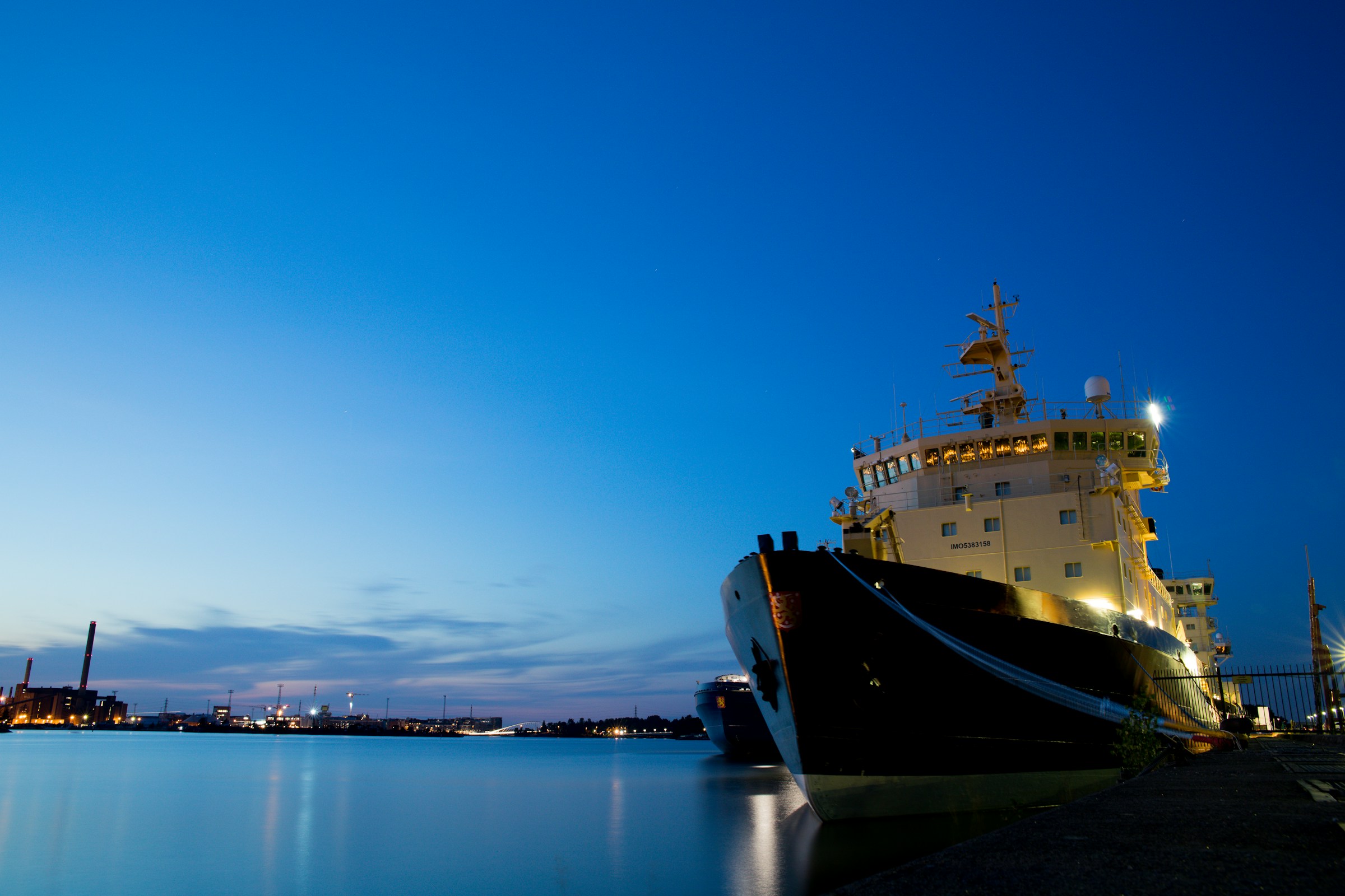 Commercial vessel moored at harbour during blue hour